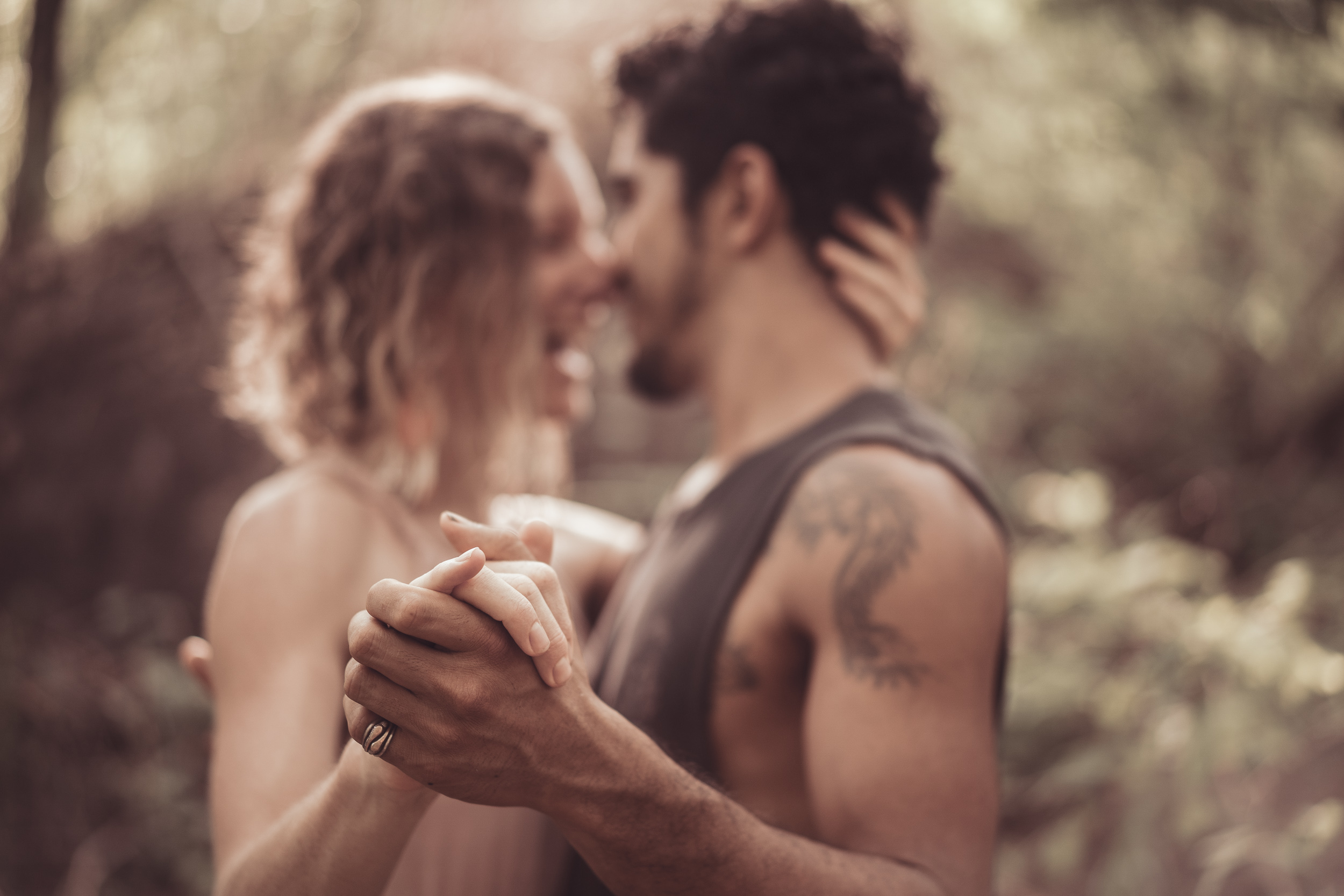 A couple dancing close, foreheads nearly touching, hands clasped